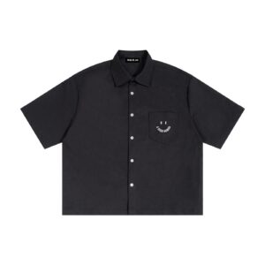 Black short-sleeve button-up shirt with a front chest pocket featuring the text 'BE A GOOD HUMAN' on a plain background